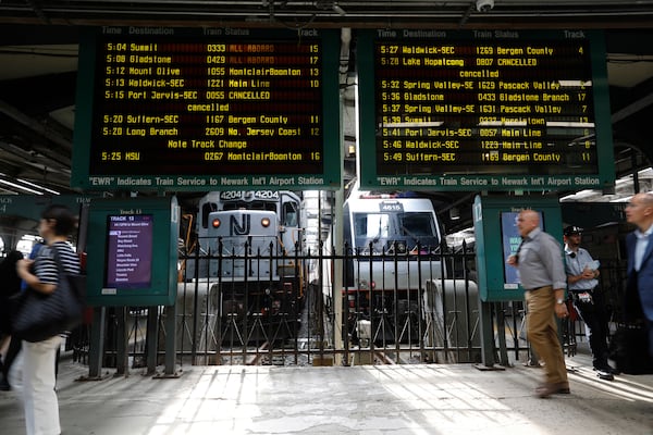 FILe - People head to trains at the New Jersey Transit station in Hoboken, N.J., on Tuesday, Aug. 7, 2018. (AP Photo/David Boe, File)