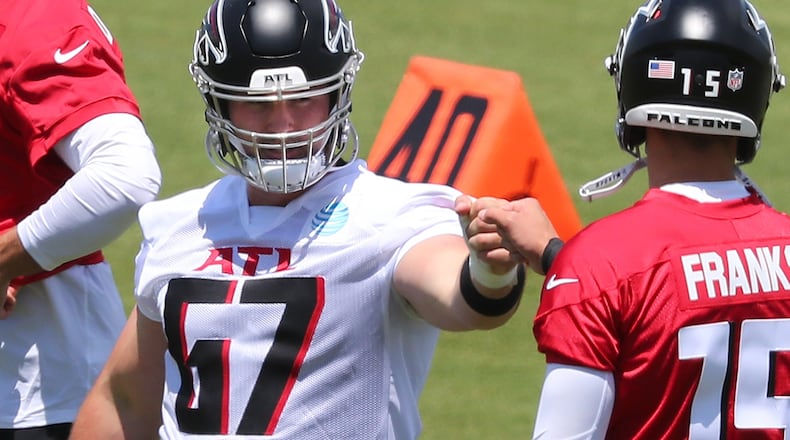 Falcons rookie offensive lineman Drew Dalman first-bumps rookie quarterback Feleipe Franks after a play during rookie minicamp on Friday, May 14, 2021, in Flowery Branch. (Curtis Compton / Curtis.Compton@ajc.com)