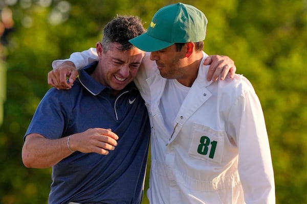 Rory McIlroy, of Northern Ireland, hugs caddie Harry Diamond, right, after winning in a playoff against Justin Rose, of England, after the final round the Masters golf tournament, Sunday, April 13, 2025, in Augusta, Ga. (AP Photo/David J. Phillip)