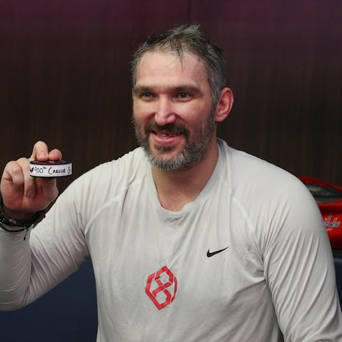 Washington Capitals left wing Alex Ovechkin poses in the locker room with his 900th NHL career goal puck in an NHL hockey game against St. Louis Blues, Wednesday, Nov. 5, 2025, in Washington. (AP Photo/Nick Wass)