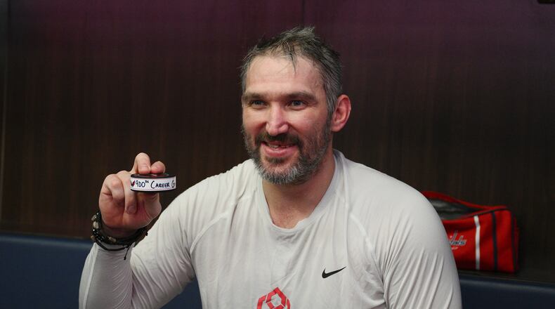 Washington Capitals left wing Alex Ovechkin poses in the locker room with his 900th NHL career goal puck in an NHL hockey game against St. Louis Blues, Wednesday, Nov. 5, 2025, in Washington. (AP Photo/Nick Wass)