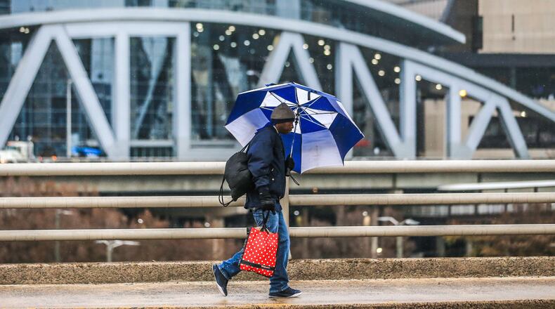 Dwayne Smith holds off the rain with his umbrella as he passes the Philips Arena. Atlanta is still free of snow, but it's under a winter weather advisory.