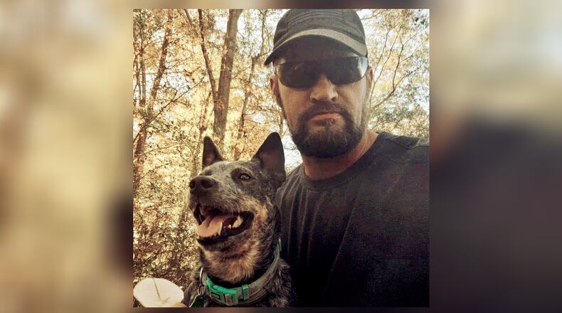 Christopher Burkett, shown with his dog Kiah, was killed in November 2021 while trying to help two women get out of a train's path. He was 47.