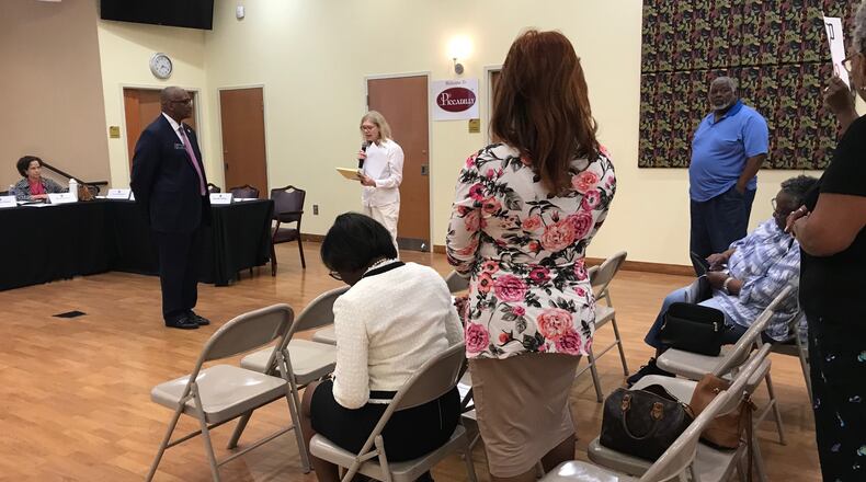 State Sen. Emanuel Jones, D-Lithonia (standing at left) listens to public comment from Mary Hinkel (center, in white) during the DeKalb County Delegation's town hall meeting on Sept. 16, 2019. Other members of the audience stand in support of Hinkel, who opposes the ethics referendum. (TIA MITCHELL/TIA.MITCHELL@AJC.COM)