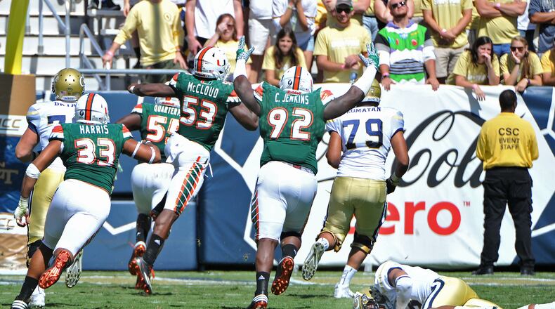 Georgia Tech Yellow Jackets quarterback Justin Thomas falls down as Miami Hurricanes linebacker Shaquille Quarterman runs for a touchdown after he stole the ball from Justin Thomas in the first half at Bobby Dodd Stadium on Saturday, October 1, 2016. HYOSUB SHIN / HSHIN@AJC.COM