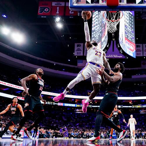 FILE - Los Angeles Lakers' LeBron James, center left, goes up for the shot against Philadelphia 76ers' Joel Embiid, center right, during the second half of an NBA basketball game, Dec. 7, 2025, in Philadelphia. (AP Photo/Chris Szagola, File)