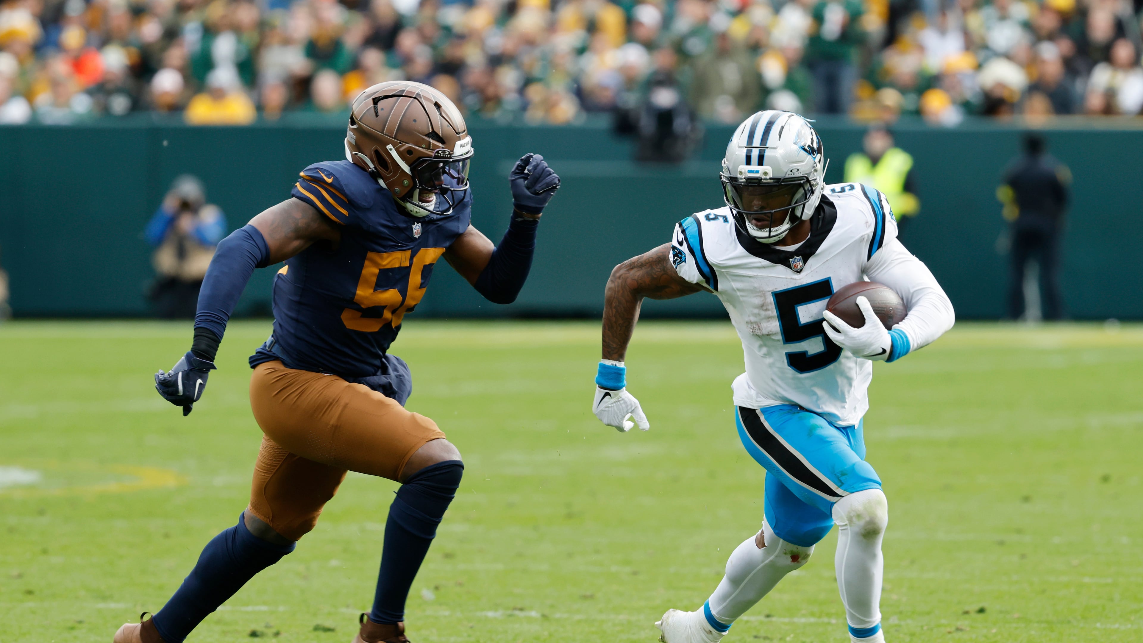 Carolina Panthers running back Rico Dowdle (5) runs against Green Bay Packers defensive end Kingsley Enagbare (55) during the second half of an NFL football game Sunday, Nov. 2, 2025, in Green Bay, Wis. (AP Photo/Mike Roemer)