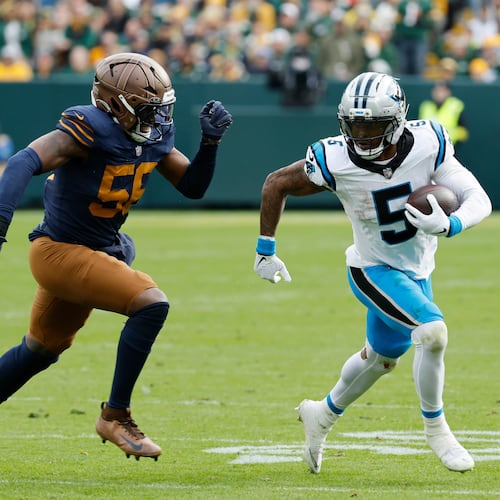 Carolina Panthers running back Rico Dowdle (5) runs against Green Bay Packers defensive end Kingsley Enagbare (55) during the second half of an NFL football game Sunday, Nov. 2, 2025, in Green Bay, Wis. (AP Photo/Mike Roemer)