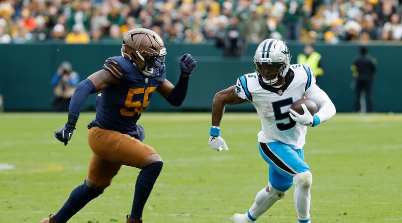 Panthers running back Rico Dowdle (right) runs against Packers defensive end Kingsley Enagbare on Sunday, Nov. 2, 2025, in Green Bay, Wis. Dowdle is turning in a spectacular season for Carolina. (Mike Roemer/AP)