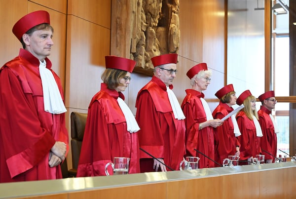 The Second Senate of the Federal Constitutional Court, from left: Thomas Offenloch, Astrid Wallrabenstein, Ulrich Maidowski, Doris König (Chairwoman of the Second Senate), Christine Langenfeld, Rhona Fetzer, Peter Frank, announce the verdict on U.S. drone missions via Ramstein, in Karlsruhe, Germany, Tuesday July 15, 2025. (Uli Deck/dpa via AP)