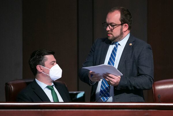 Council members Amir Farokhi (left) and Dustin Hillis confer as the Atlanta City Council held their first in person meeting since they were suspended at start of the pandemic In Atlanta on Monday, March 21, 2022.   (Bob Andres / robert.andres@ajc.com)