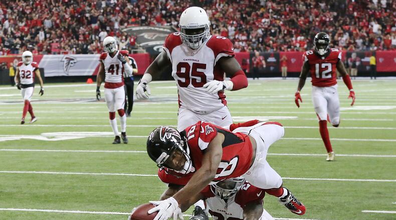Falcons wide receiver Taylor Gabriel dives over Cardinals safety Tony Jefferson into the end zone for a touchdown and a 31-13 lead during the fourth quarter in an NFL football game on Sunday, Nov. 27, 2016, in Atlanta. The Falcons beat the Cardinals 38-19. (Curtis Compton/Atlanta Journal-Constitution via AP)