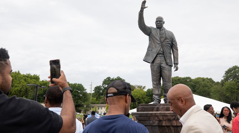 A man takes a photo of the new John Lewis statue at Rodney Cook, Sr. Park in Vine City in Atlanta, GA., on Wednesday, June 7, 2021. (Photo/ Jenn Finch for the Atlanta Journal Constitution)