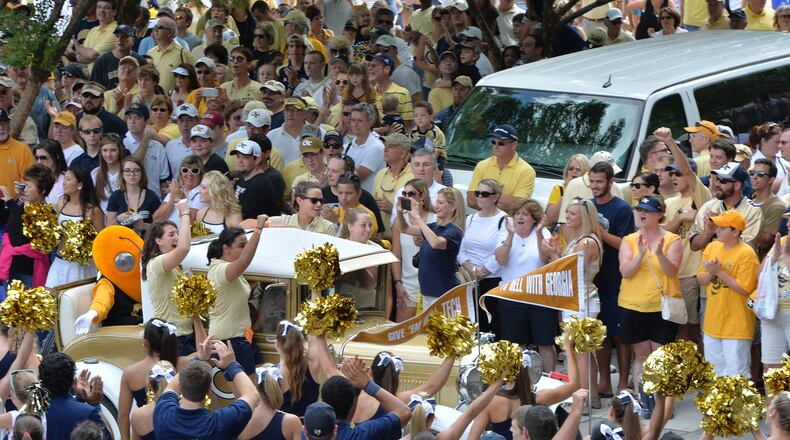 Georgia Tech’s Ramblin’ Wreck leads the band and cheerleaders through hundreds of fans down Yellow Jacket Alley before the start of the Georgia Tech season opener against the Wofford Terriers at Bobby Dodd Stadium on Saturday, August 30, 2014. HYOSUB SHIN / HSHIN@AJC.COM