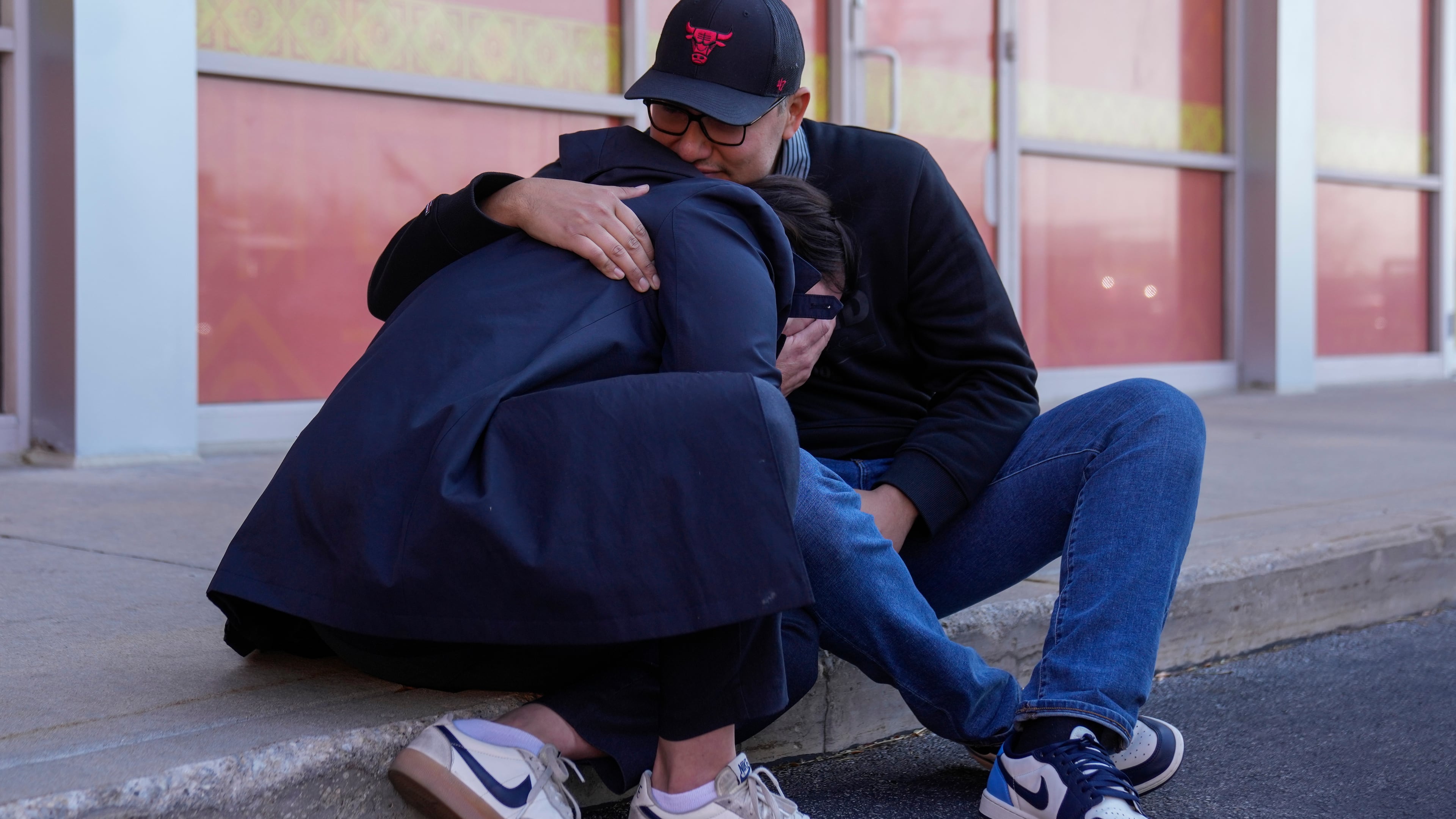 Maria Guzman, left, and Sergio Rocha, parents of young children, comfort each other outside of Rayito de Sol Spanish Immersion Early Learning Center after federal immigration agents took a daycare teacher Wednesday, Nov. 5, 2025, in Chicago. (AP Photo/Erin Hooley)