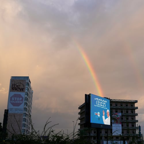A rainbow rises behind a billboard featuring Pope Leo XIV in Beirut, Lebanon, Monday, Dec. 1, 2025. (AP Photo/Hassan Ammar)