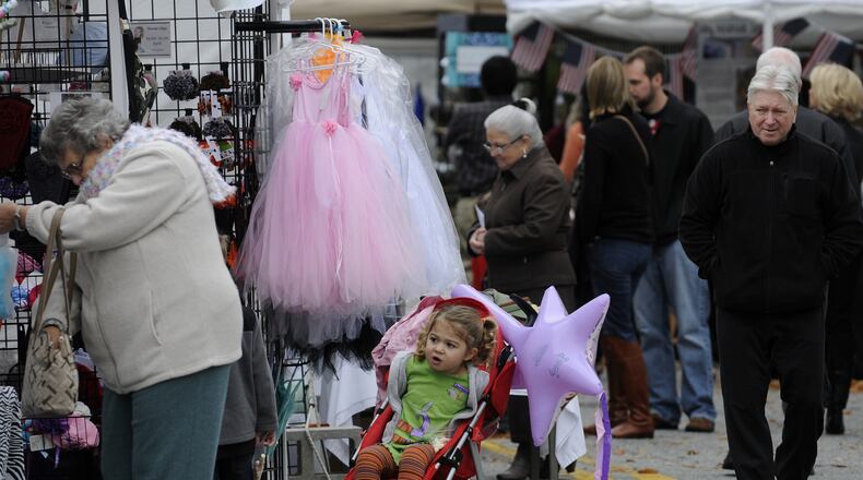 Lily Fortner, 3, peeks at artwork while her mom (not pictured) shops at the Smyrna Fall Jonquil Festival.