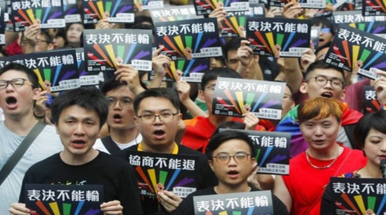Supporters of same-sex marriages in Taiwan gather in Taipei on Friday with signs that read  'Vote Can't Be Defeated..''