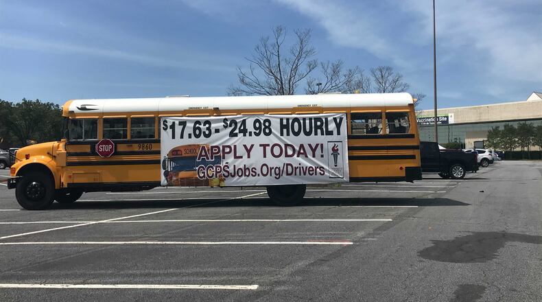 A Gwinnett County Public Schools bus sits outside the Gwinnett Place mass COVID-19 vaccination site on April 15, 2021. Gwinnett gave raises to all school bus drivers, including new hires. (Vanessa McCray / AJC)