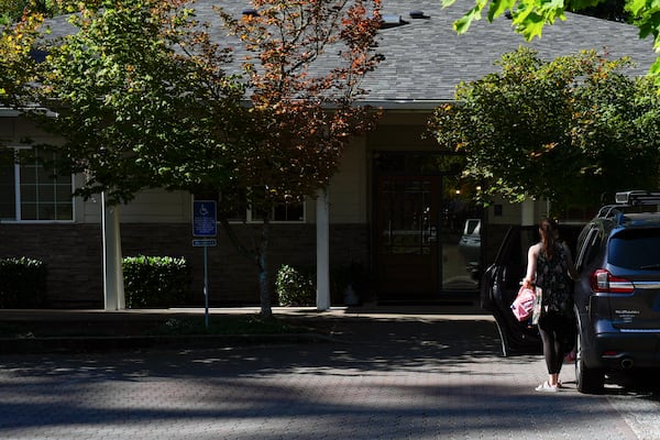 A guardian drops off a child at the Guidepost Montessori school on Friday, July 18, 2025, in Beaverton, Ore. (AP Photo/Jenny Kane)