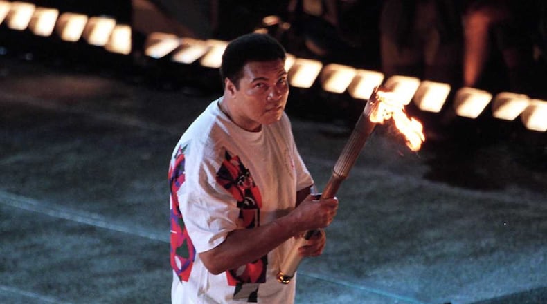 Muhammad Ali lights the torch to launch the 1996 Olympics in Atlanta. AJC file photo