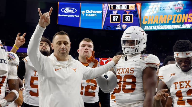 Texas Longhorns coach Steve Sarkisian and defensive lineman Trill Carter (98) stand before the band as the "Eyes of Texas" is played following their loss to the Washington Huskies in the Sugar Bowl at Caesars Superdome in New Orleans, Monday, Jan. 1, 2024. The Longhorns lost to the Huskies in a College Football Playoff semifinal game. (Tom Fox/The Dallas Morning News/TNS)