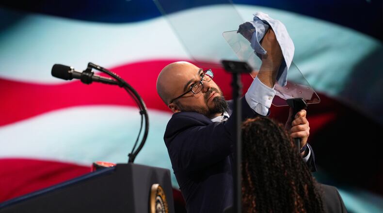 FILE - Gabriel Perez cleans the teleprompter before President Donald Trump speaks at the Future Investment Initiative Institute's summit, March 27, 2026, in Miami Beach, Fla. (AP Photo/Mark Schiefelbein, File)