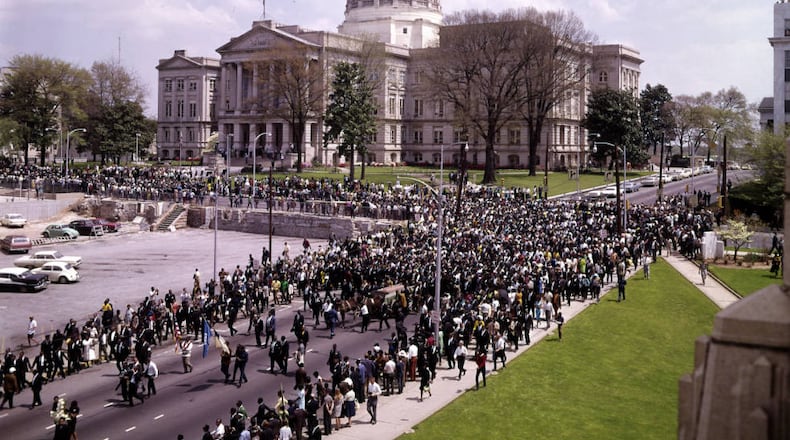 The funeral procession for Martin Luther King Jr. passes in front of Atlanta City Hall (out of frame) near the Georgia Capitol building. The flag in front of the Capitol building is flying at half-staff over the objection of Gov. Lester Maddox. (J. C. Lee / AJC Collection at GSU Library AJCNS1968-04-09c)