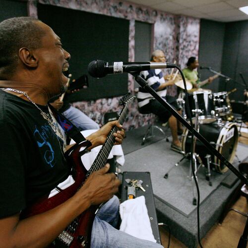 FILE - Andre "Dadou" Pasquet, left, sings and plays guitar with the Magnum compas band during a practice session in North Miami, Fla. Thursday, May 8, 2008. (AP Photo/Lynne Sladky, File)