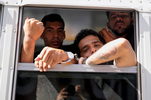 Colombian migrants look out from a Panamanian immigration bus transporting them from a migrant reception center in Lajas Blancas, where they arrived after crossing the Darien Gap en route to the U.S. southern border, to a police station in Panama City, March 11, 2025. (AP Photo/Matias Delacroix)