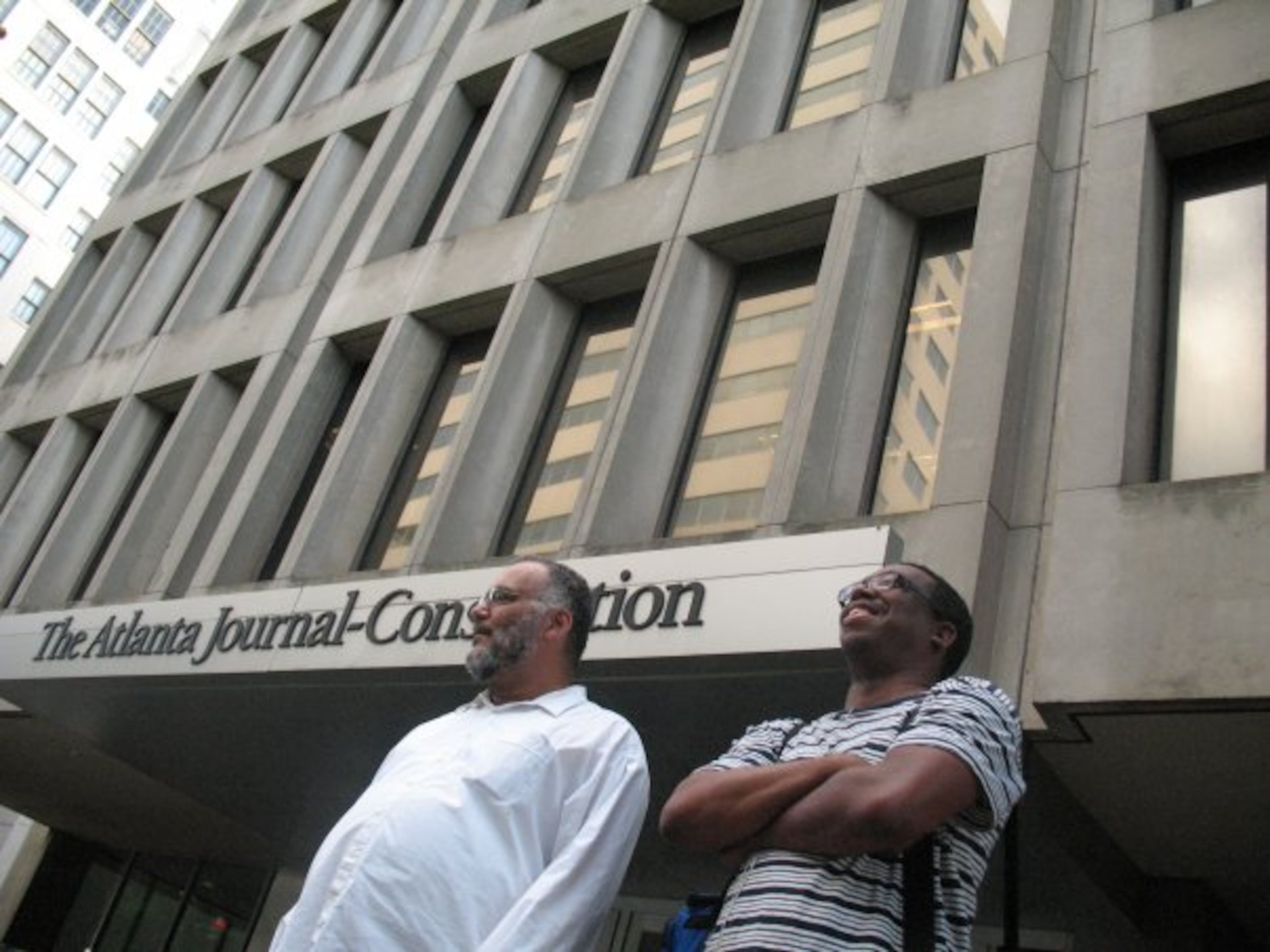 David Gibson (left) and Ernie Suggs stand outside the former home of The Atlanta Journal-Constitution at 72 Marietta St. In that old building, the most exciting time of day was between 5 and 6 p.m., when deadlines loomed, Suggs writes. (AJC File)