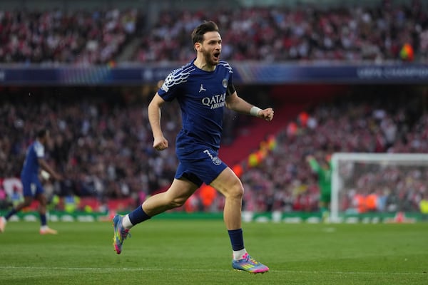 PSG's Khvicha Kvaratskhelia celebrates after his teammate Ousmane Dembele scoring his side's opening goal during the Champions League semifinal first leg soccer match between Arsenal and Paris Saint-Germain at Emirates Stadium in London, England, Tuesday, April 29, 2025. (AP Photo/Kirsty Wigglesworth)