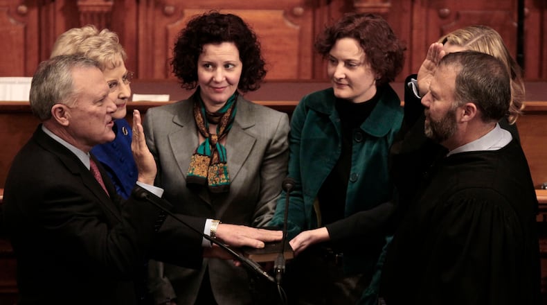 Gov. Nathan Deal, left is sworn in by his son, Hall County Superior Judge Jason Deal, as the 82nd Governor in the House chamber on Jan. 10, 2011, in Atlanta. Behind Governor Deal, from left, is his wife Sandra Deal, Mary Emily O’Bradovich, Carrie Deal Wilder and Katie Deal Wright. (AP Photo/John Bazemore, Pool)
