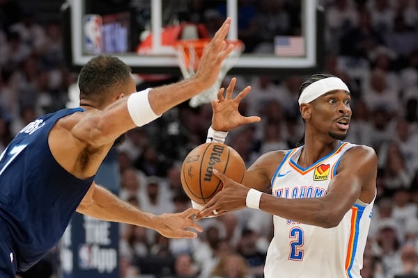 Oklahoma City Thunder guard Shai Gilgeous-Alexander (2) looses controls of the ball while defended by Minnesota Timberwolves center Rudy Gobert (27) during the first half of Game 3 of the Western Conference finals of the NBA basketball playoffs, Saturday, May 24, 2025, in Minneapolis. (AP Photo/Abbie Parr)
