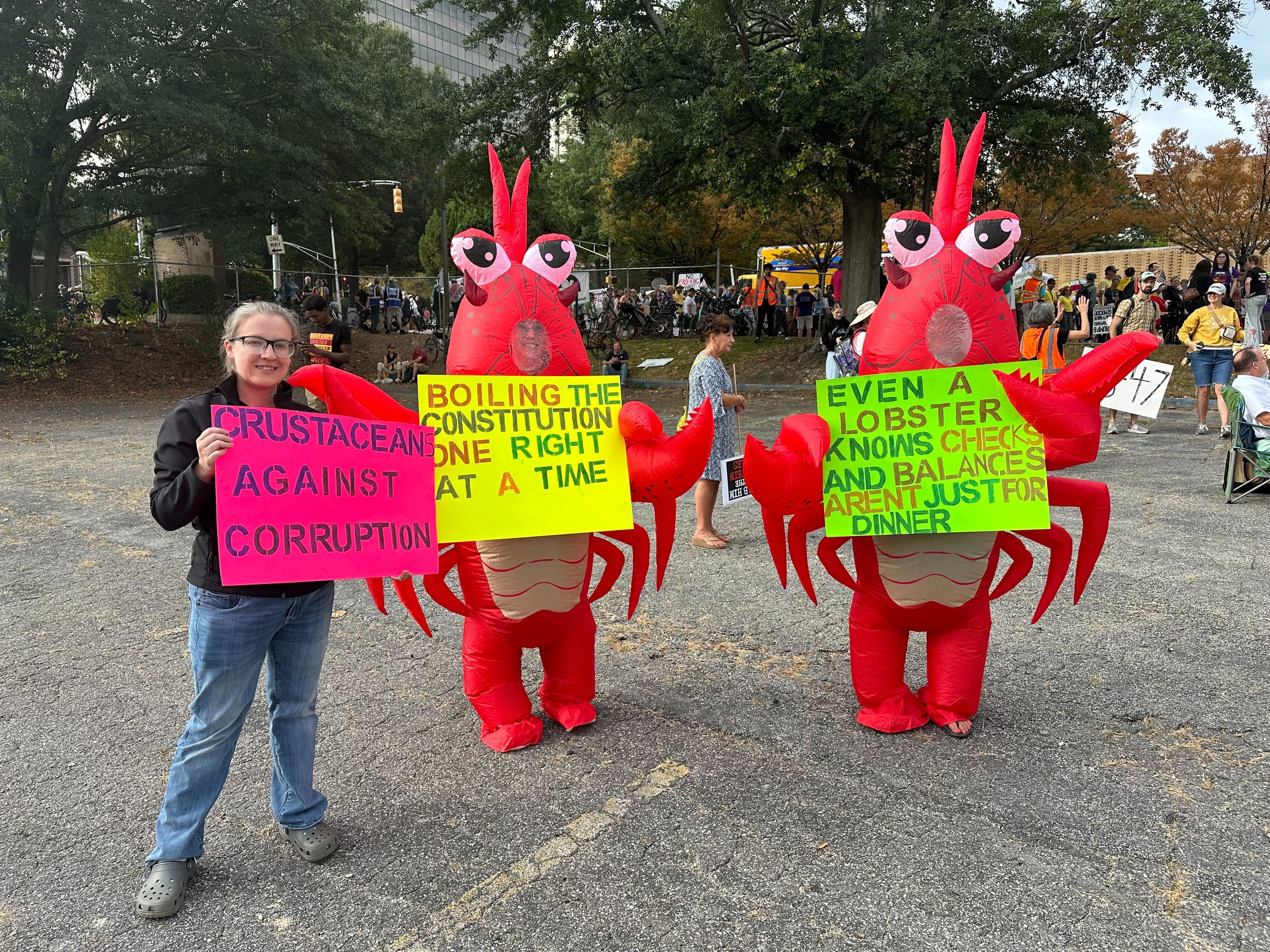 Two people dressed up a lobsters attended the Atlanta "No Kings" protest. They coined themselves as "Crustacean Against Corruption." (Amy Wenk / AJC)