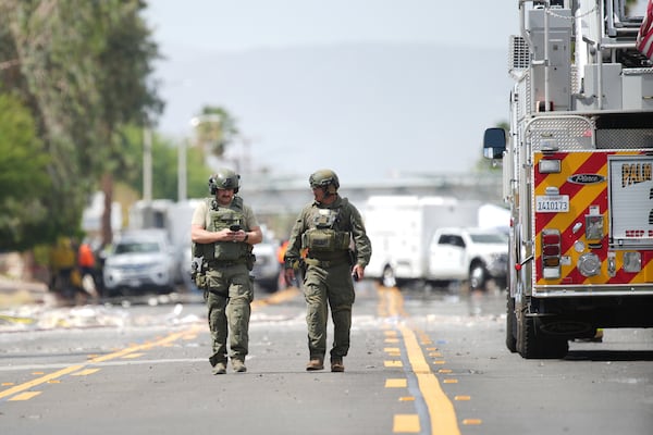 Sheriffs deputies walk near the scene of an explosion Saturday, May 17, 2025, in Palm Springs, Calif. (AP Photo/Eric Thayer)