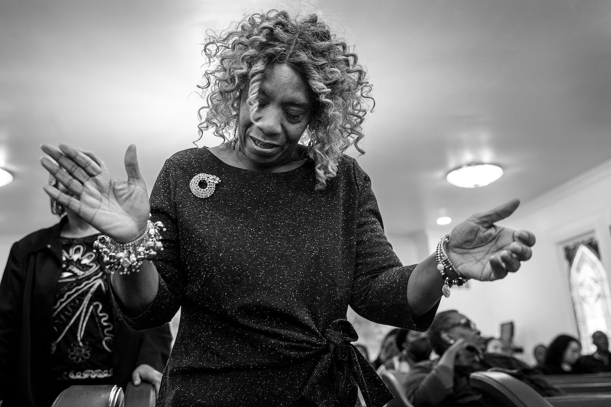 A mourner is swept up in gospel song during the homegoing of Marcus Johnson at Willie Watkins Funeral Home chapel on Nov. 11, 2023. (Arvin Temkar / arvin.temkar@ajc.com)