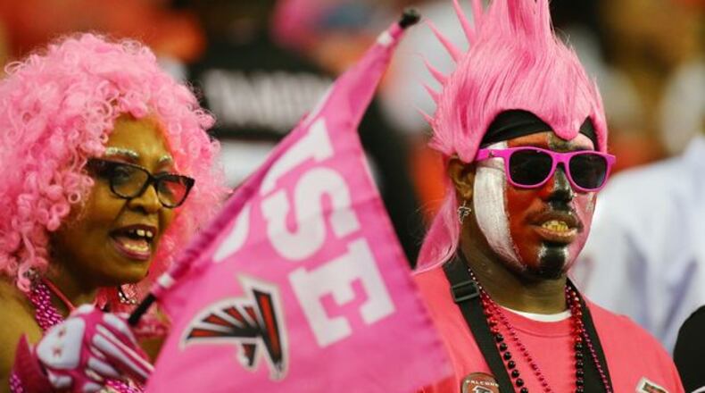 Falcons fans Lula and Charles Motin, LaGrange, wear pink for breast cancer awareness to watch their team give up a ton of explosive plays against the Bears on Sunday, Oct. 12, 2014, in Atlanta. (Curtis Compton)