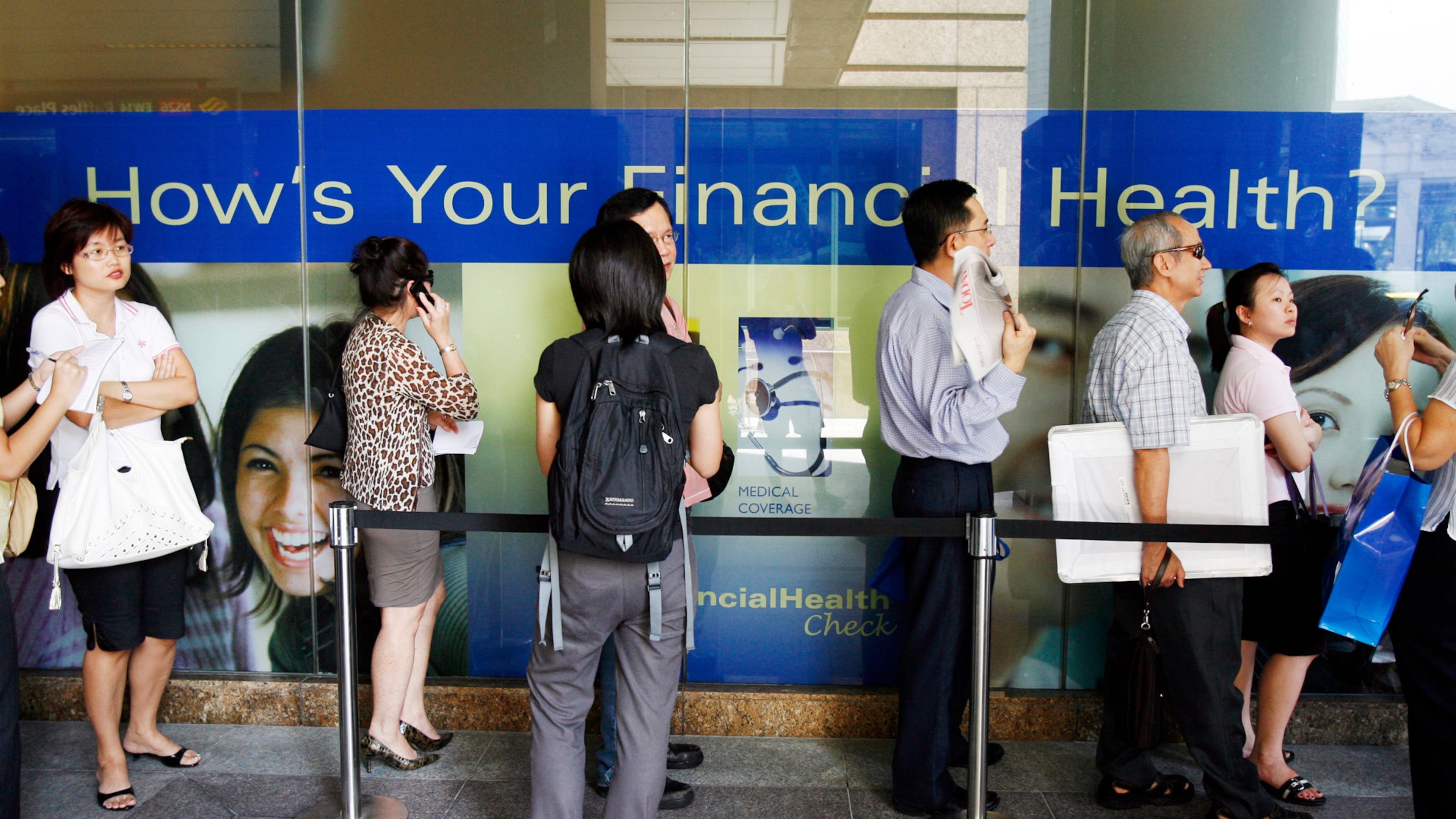FILE -Customers of American International Assurance (AIA), a wholly owned subsidiary of American Insurance Group (AIG) stand in line outside the AIA office as they wait to speak to customer service officers, and some others seeking advice on terminating their insurance policies on Tuesday Sept. 16, 2008 in Singapore amid fears that that American Insurance Group, the world's largest insurer, was fighting for its survival after downgrades from major credit rating firms, adding pressure as AIG seeks billions of dollars to strengthen its balance sheet.(AP Photo/Wong Maye-E, File)