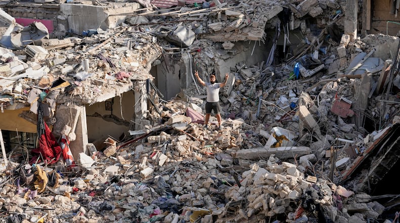 A man who returns to his village following the announcement of an initial ceasefire agreement between the United States and Iran, flashes victory sign as he stands on the rubble of his destroyed house in Nabatiyeh town, southern Lebanon, Tuesday, June 16, 2026. (AP Photo/Hussein Malla)