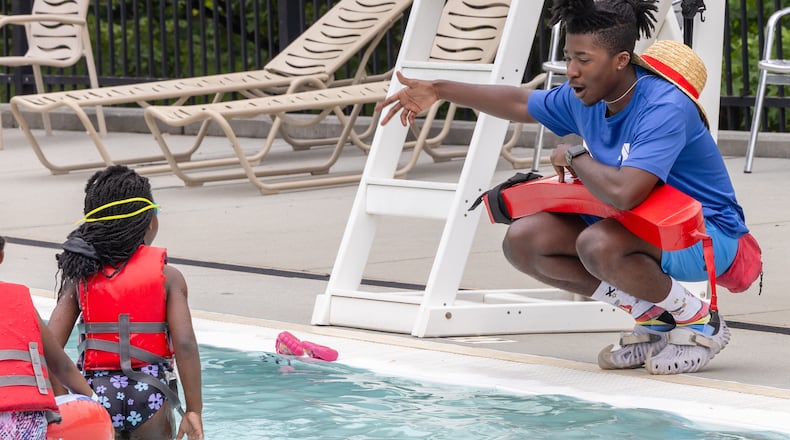 Lifeguard Tyler Norris (right) talks with a swimmer at the East Lake Family YMCA pool in Atlanta on June 28th, 2024. The City of Atlanta has partnered with the YMCA of Metro Atlanta to offer free summer lifeguard training, and pay while being trained. This is for city residents, 16-24.The lifeguards at East Lake Family YMCA have all gone through the free training. PHIL SKINNER FOR THE ATLANTA JOURNAL-CONSTITUTION