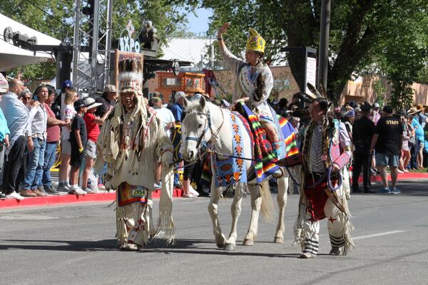 A participant in the Gathering of Nations horse parade waves to the crowd at the state fairgrounds in Albuquerque, New Mexico, on Friday, May 25, 2025 (AP Photo/Susan Montoya Bryan)
