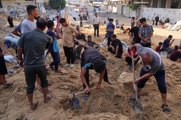 Palestinians dig through sand looking for belongings after an Israeli strike hit a displacement tent camp in Gaza City, Saturday, June 28, 2025. (AP Photo/Jehad Alshrafi)