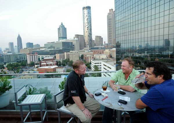 From left, Mike Metzen, Mick Mulcahey, and Mark Bonjovi, all from Los Angeles, Calif., relax at 11 Stories, a bar on the Glenn Hotel’s rooftop.