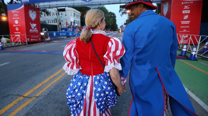Reg and Paula Barnes, dressed as Sam and Betsy Ross, arrive to hold the finish line tape for the 47th running of the AJC Peachtree Road Race at Piedmont Park on Monday, July 4, 2016, in Atlanta. Curtis Compton / ccompton@ajc.com