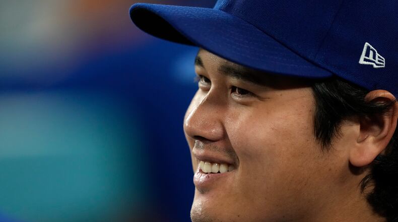 Los Angeles Dodgers' Shohei Ohtani smiles as he sits in the dugout during the eighth inning of a baseball game against the San Diego Padres, Tuesday, Sept. 22, 2026, in Los Angeles. (AP Photo/Mark J. Terrill)
