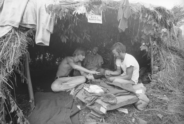 FILE - Music fans seek shelter in a grass hut at the Woodstock Music and Art Festival in Bethel, N.Y., Aug. 17, 1969. (AP Photo/File)