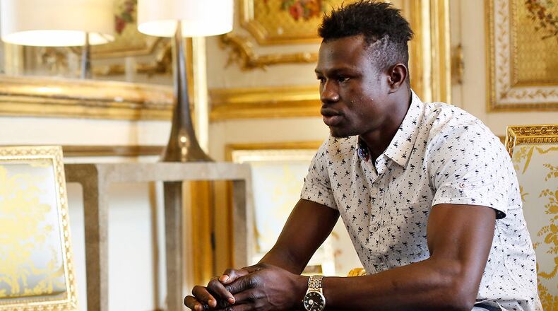 Mamoudou Gassama, 22, from Mali, is pictured during a meeting with French President Emmanuel Macron at the presidential Elysee Palace in Paris, Monday, May, 28, 2018. Mamoudou Gassama living illegally in France is being honored by Macron for scaling an apartment building over the weekend to save a 4-year-old child dangling from a fifth-floor balcony. (AP Photo/Thibault Camus, Pool)