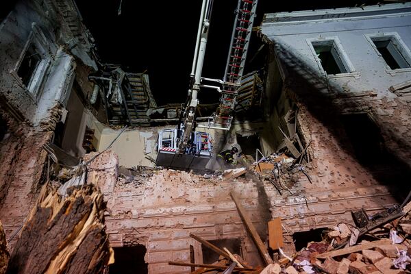 Rescue workers clear the rubble of a university building destroyed by a Russian missile strike on Sumy, Ukraine, Sunday, April 13, 2025. (AP Photo/Evgeniy Maloletka)