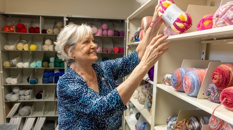 Happy Caps founder Kathy DeJoseph grabs more supplies in the yarn room for Happy Caps volunteers as they knit caps for patients at the Wellstar West Cobb Medical Center in Marietta, Georgia. (Phil Skinner for the AJC)